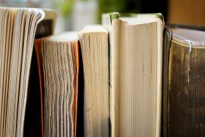 A group of old books next to each other on a shelf.